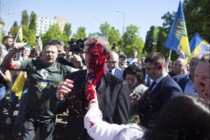 Read more about the article Protesters cover the Russian ambassador with blood-red paint.